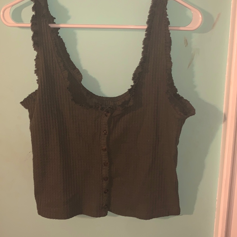A green tank top with brownish buttons